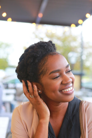 smiling woman with natural hair stroking the side of her head - marshmallow root for hair